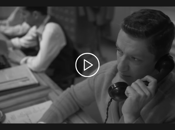 Cette image en noir et blanc montre un homme au téléphone (un ancien téléphone filaire). Il s'agit d'une capture d'écran de la campagne de BETC célébrant les 80 ans d'EDF.